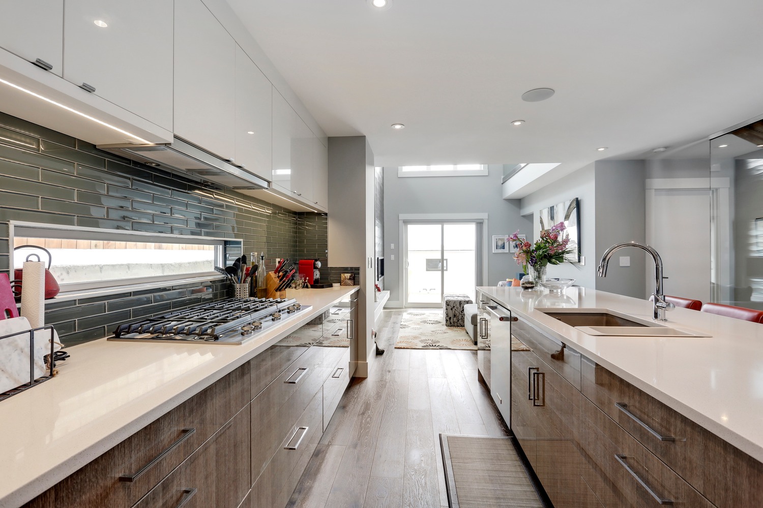 Chef's kitchen with two-tone cabinetry and green glass subway tile backsplash