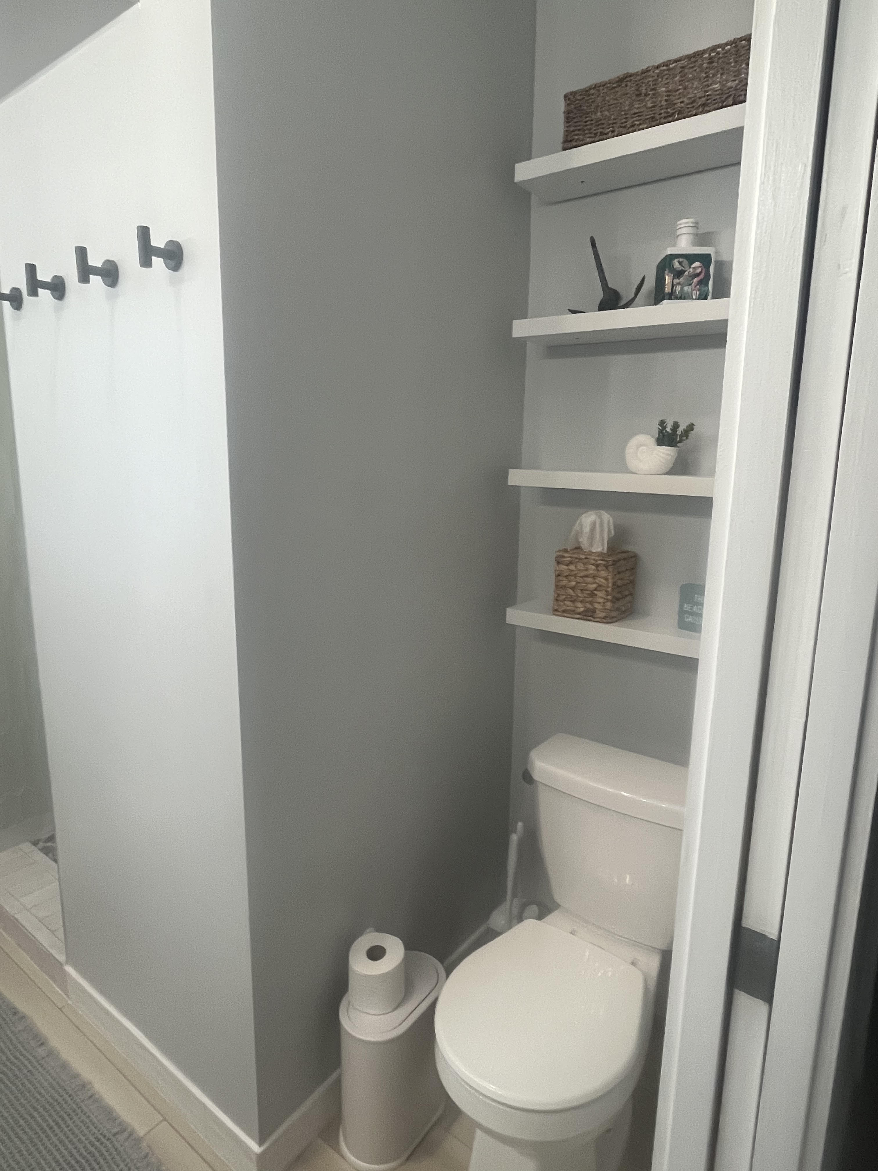 Walk-in shower with sage green picket tile and pebble mosaic floor